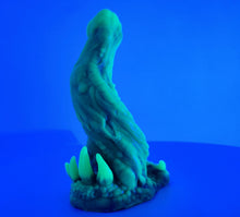 Load image into Gallery viewer, A coated color "Doomstick" tentacle themed adult toy shown from the side in UV lighting.