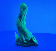 Load image into Gallery viewer, A coated color "Doomstick" tentacle themed adult toy shown from the side in UV lighting.