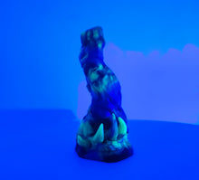 Load image into Gallery viewer, A three color marble "Doomstick" tentacle themed adult toy shown from the side under UV lighting.