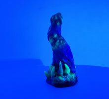 Load image into Gallery viewer, A three color marble "Doomstick" tentacle themed adult toy shown from the side under UV lighting.