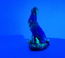 Load image into Gallery viewer, A three color marble "Doomstick" tentacle themed adult toy shown from the side under UV lighting.