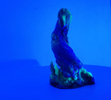 Load image into Gallery viewer, A three color marble "Doomstick" tentacle themed adult toy shown from the side under UV lighting.