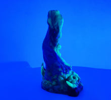 Load image into Gallery viewer, A three color marble "Doomstick" tentacle themed adult toy shown from the side under UV lighting.