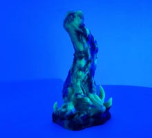 Load image into Gallery viewer, A three color marble "Doomstick" tentacle themed adult toy shown from the side under UV lighting.