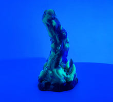 Load image into Gallery viewer, A three color marble "Doomstick" tentacle themed adult toy shown from the side under UV lighting.