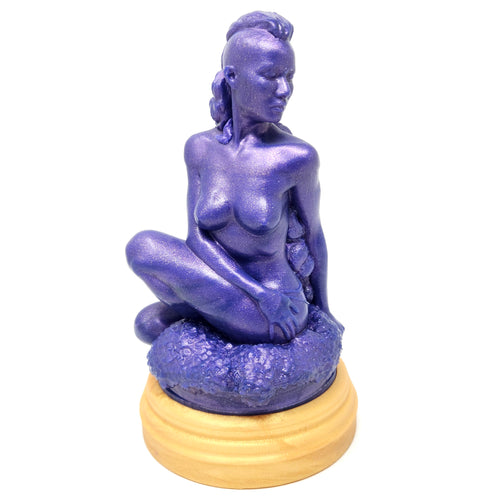 A silicone penetratable sculpture of Jet Setting Jasmine in dark, shimmery purple sitting on her gold stand silicone base, on a white background.