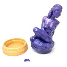 Load image into Gallery viewer, A silicone penetratable sculpture of Jet Setting Jasmine in dark, shimmery purple sitting next to her gold stand silicone base, on a white background. The removable suction and cleaning plug is removed from the sculpture. The matching dark purple plug is next to the sculpture and base.
