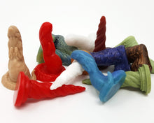 Load image into Gallery viewer, A small pile of various colors and designs of the silicone mini charms on a white background
