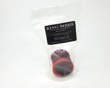 Load image into Gallery viewer, Double-Sided Suction Cup with King Noire's logo in 2 color marble of Gloss Red and Sparkling Black inside a clear plastic bag with a black label on a white background