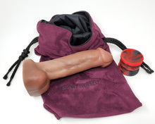 Load image into Gallery viewer, Realistic airbrushed dildo of King Noire's likeness with a Double-Sided Suction Cup and Royal Fetish Toy Bag on a white background