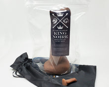 Load image into Gallery viewer, Packaged King Noire adult toy standing up on a black satin bag with a mini charm toy on a white background