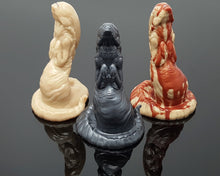 Load image into Gallery viewer, The Lust Burster by Lust Arts in three colors on a reflective black background