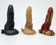 Load image into Gallery viewer, The Lust Burster by Lust Arts in three colors on a reflective black background, back view