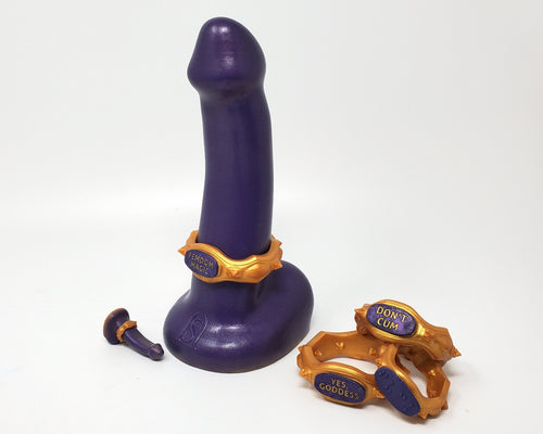 A dual-density FEMDOM insertable adult toy with an Edging Body Band next to a stack of bands at a mini charm on a white background