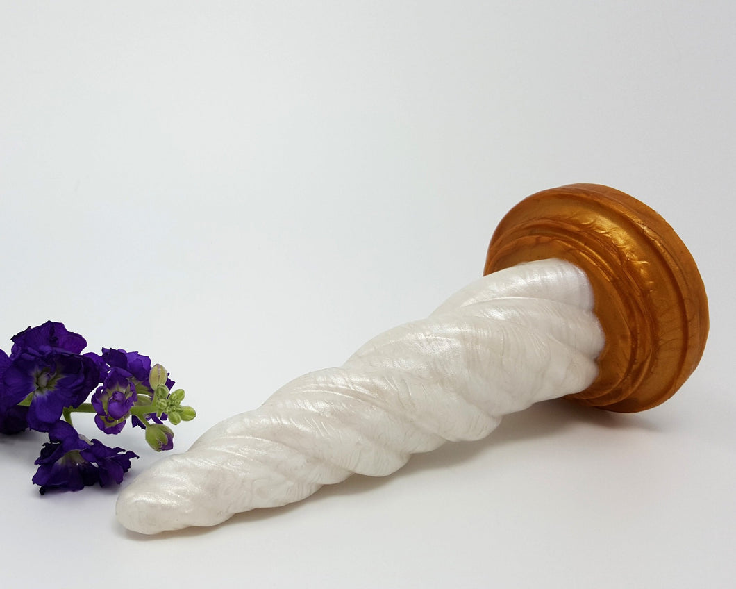 A Sunlight color Unicorn Horn insertable toy on its side with purple flowers on a white background