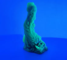 Load image into Gallery viewer, A coated color &quot;Doomstick&quot; tentacle themed adult toy shown from the side in UV lighting.
