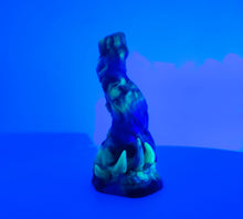 Load image into Gallery viewer, A three color marble &quot;Doomstick&quot; tentacle themed adult toy shown from the side under UV lighting.
