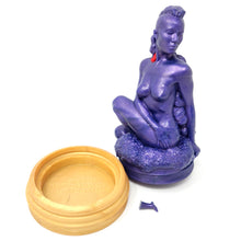 Load image into Gallery viewer, A silicone penetratable sculpture of Jet Setting Jasmine in dark, shimmery purple sitting next to her gold stand silicone base, on a white background. There is a bright red removable suction and cleaning plug in the sculpture. The matching dark purple plug is next to the sculpture and base.
