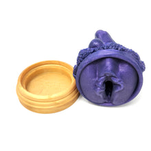 Load image into Gallery viewer, A silicone penetratable sculpture of Jet Setting Jasmine in dark, shimmery purple laying on her side showing her vulva sculpture underside. This is next to her gold stand silicone base, all on a white background.
