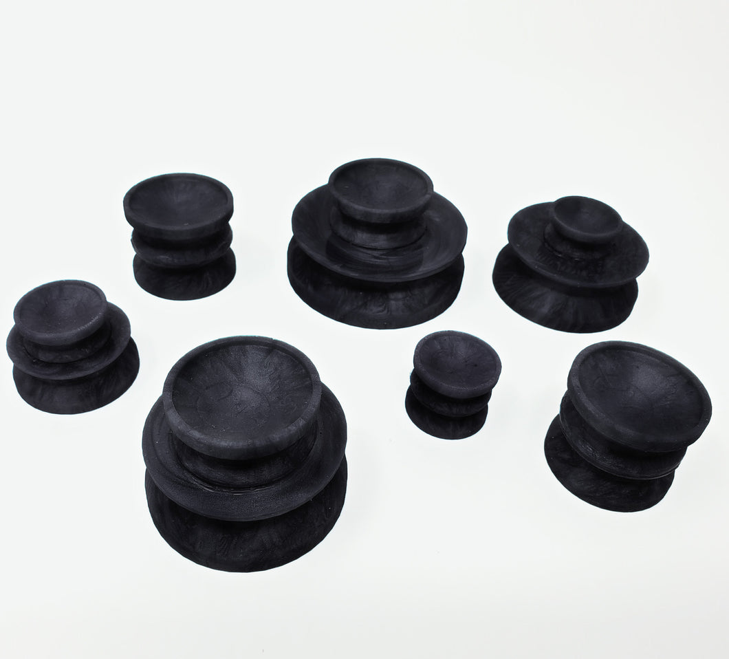 Seven Double-Sided Suction Cups from Lust Arts in a marble black color in a range of mixed and matched sizes