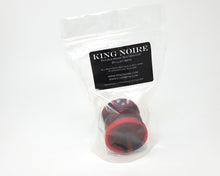 Load image into Gallery viewer, Double-Sided Suction Cup with King Noire&#39;s logo in 2 color marble of Gloss Red and Sparkling Black inside a clear plastic bag with a black label on a white background
