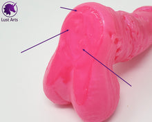 Load image into Gallery viewer, A picture that is a close-up of the base of this toy, with arrows pointing to some small bubbles in the flat of the base. 

