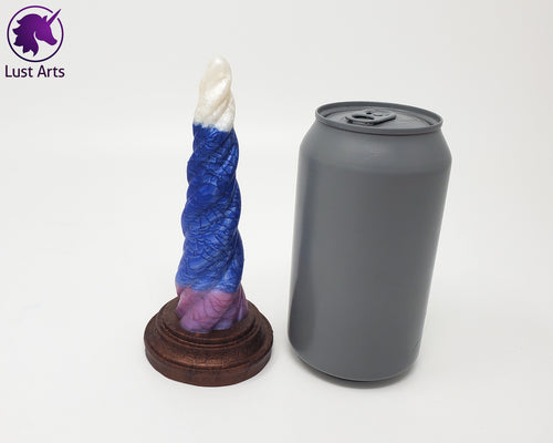 Photo of a Unicorn Horn insertable toy next to a soda can for scale on an off-white background