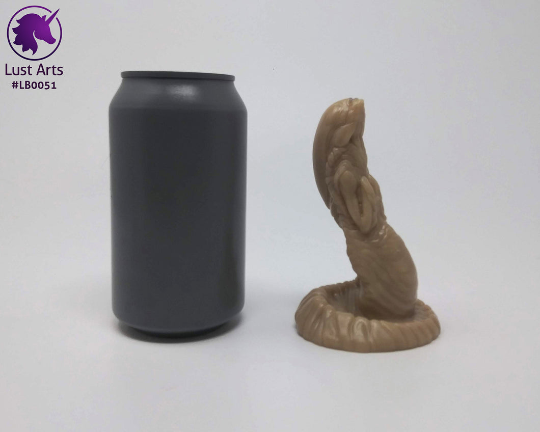 Photo of a Lust Burster insertable toy next to a soda can for scale on an off-white background