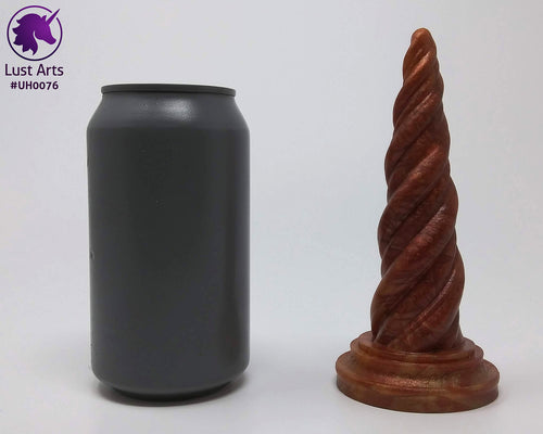 Photo of a Unicorn Horn insertable toy next to a soda can for scale on an off-white background