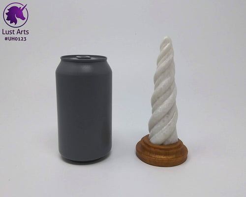 Photo of a Unicorn Horn insertable toy next to a soda can for scale on an off-white background