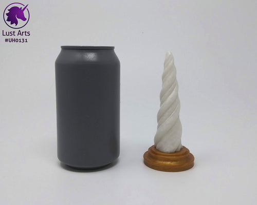 Photo of a Unicorn Horn insertable toy next to a soda can for scale on an off-white background