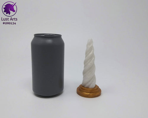 Photo of a Unicorn Horn insertable toy next to a soda can for scale on an off-white background